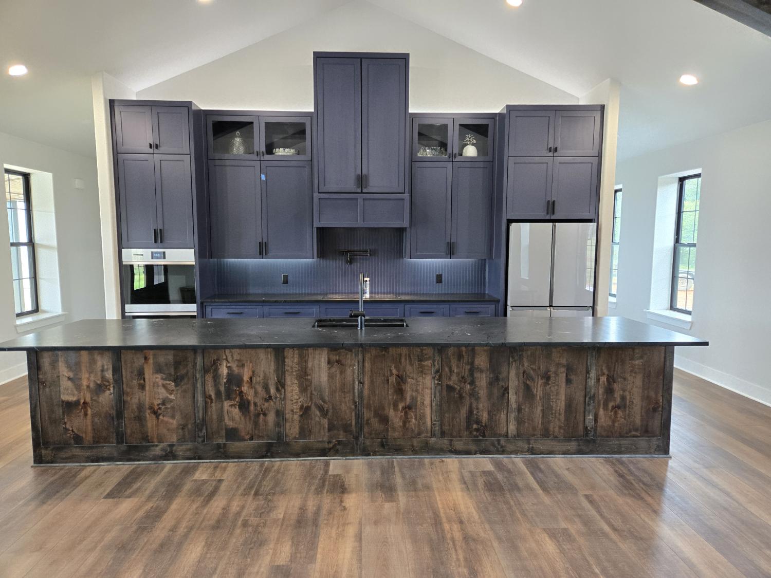 Navy cabinets, rustic wood island, and Black Diamond quartzite in a Jacksonville kitchen